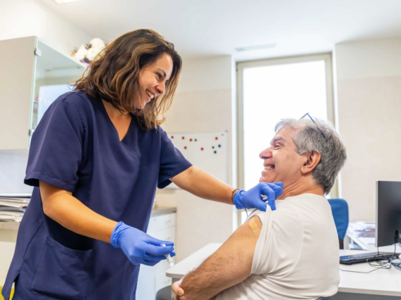 man and woman smiling after she gave him a vaccine